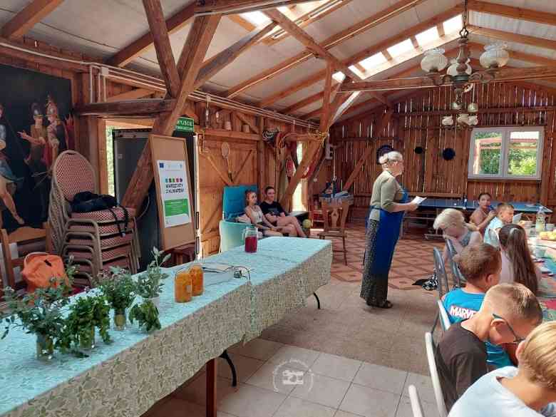 Zagroda Edukacyjna, stołówka, drewniane deski, belki stropu, stoły, krzesła, dzieci