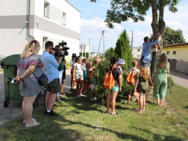 Parking za Urzędem Gminy, budynek, ogrodzenie, drzewo, trawa, ekipa TVP, Michał, dzieci, niebo