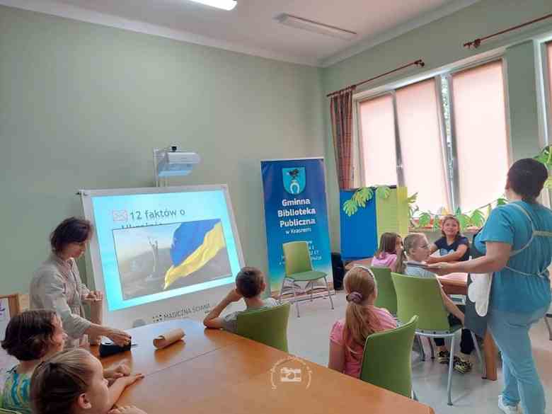 Sala konferencyjna, magiczna ściana, Pani Natalia, Pani Basia, stoły, krzesła, dzieci, baner