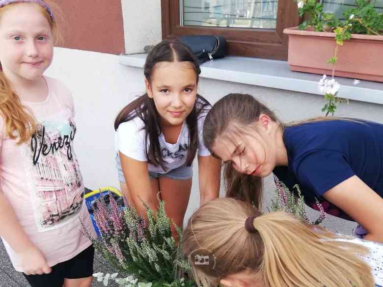 Dziewczynki podczas sadzenia roślinek w donice